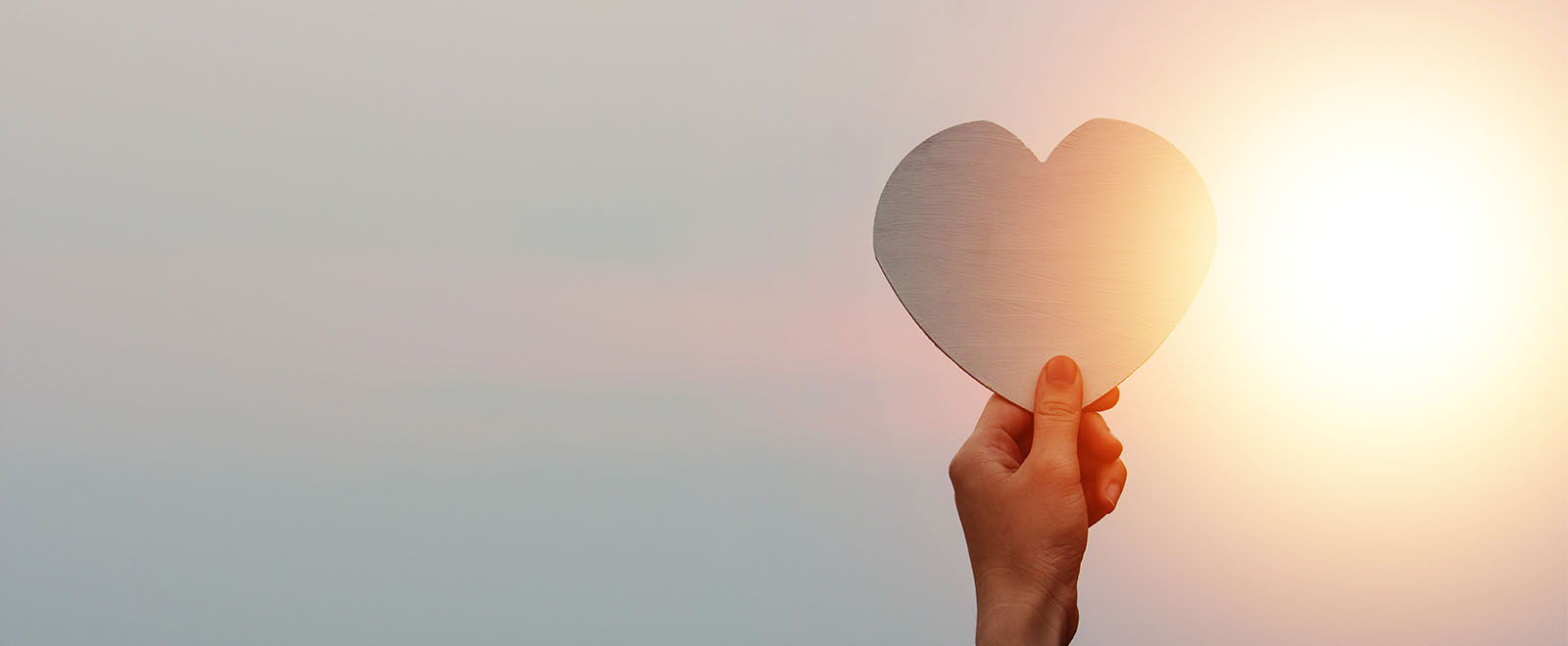 Hand holding heart on sky sunset, Love in Valentine's Day, Happy Valentine, World heart day